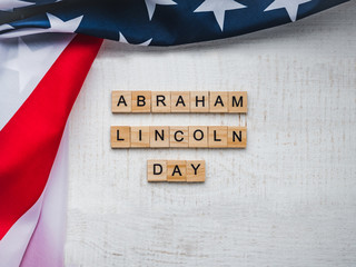 Abraham Lincoln's Birthday. Beautiful greeting card. White isolated background, close-up, top view, wooden surface. Congratulations for loved ones, relatives, friends and colleagues