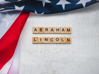 Abraham Lincoln's Birthday. Beautiful greeting card. White isolated background, close-up, top view, wooden surface. Congratulations for loved ones, relatives, friends and colleagues