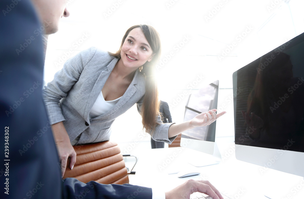 Wall mural Satisfied girl is pointing at a blank monitor screen