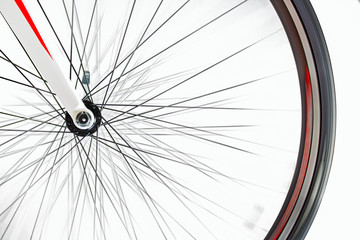 The front wheel of the bicycle rotates quickly on a white background. Detail of road bike while rotates.
