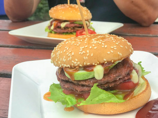 close up of homemade hamburgers with ketchup on white plate