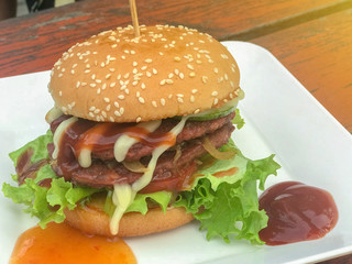 close up of homemade hamburgers with ketchup on white plate