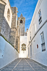 Nice street next to the church Divino Salvador, with a mural of the Virgen de la Oliva, in Vejer de la Frontera, Spain