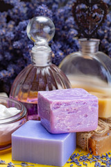 Obraz na płótnie Canvas Natural healthy aromatherapy and skin treatment with organic French lavender, lavender soap, lotion and essential oils on purple background with dried lavender flowers