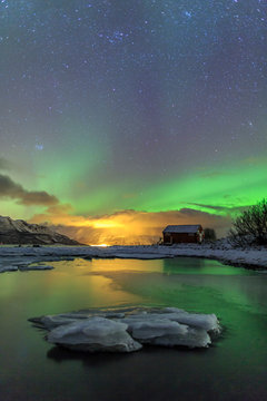 The Northern Lights illuminates the wooden cabin Oteren Storfjorden Lyngen Alps Troms&radic;&prod; Lapland Norway Europe