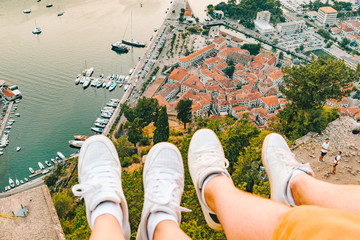 couple legs at hill with beautiful view of kotor city on background
