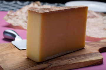 Piece of aged Comte or Gruyere de Comte, AOC French cheese made from unpasteurized cow's milk in the Franche-Comte region of eastern France with traditional methods of production.