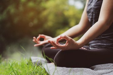 Asian Women sitting in yoga In the garden. On holiday season of the summer Relaxing muscles...