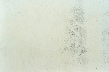 White wall with a beige yellowish color with a rough texture and a faded wash to the concrete....