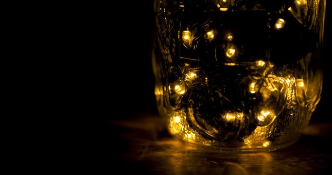 Glowing led lights inside a transparent jar in the darkness