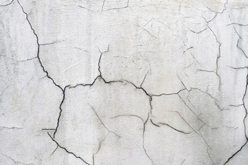 White concrete wall of the old house with curly cracks. Background