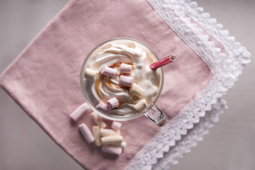 Glass cup of tasty frappe coffee with marshmallow on table, top view