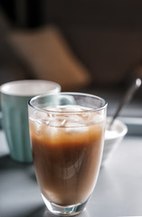 Glass of tasty frappe coffee on table
