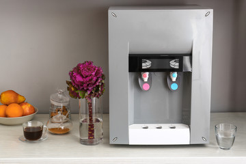 Modern water cooler on table in kitchen