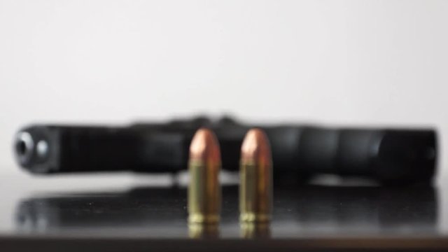 Gun and two bullets Steady shot and changing focus on 9mm bullets and gun 