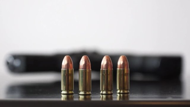 Gun and four bullets Steady shot and changing focus on 9mm bullets and gun 
