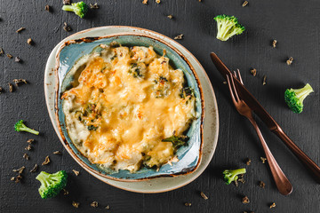 Vegetable Frittata with potato, broccoli, cheese in plate over dark background. Healthy vegan food,...