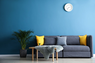 Stylish interior of room with comfortable big sofa