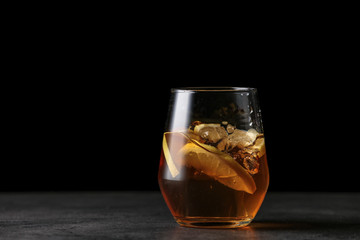 Glass of cold whiskey with splashes on dark background