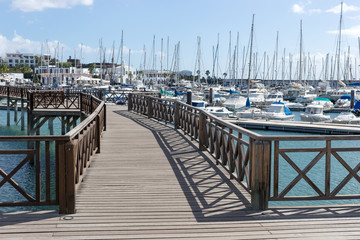 Fototapeta premium Wooden bridge at the boat harbor of Marina Rubicon in Playa Blanca. Lanzarote. Canary Island. Spain
