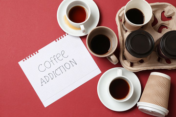 Almost empty cups of coffee and paper sheet with text COFFEE ADDICTION on color background