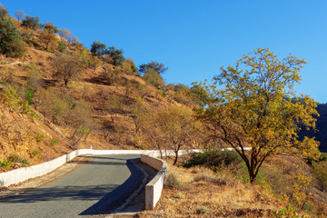 Picture of asphalt road in the mountains with dangerous turn sign