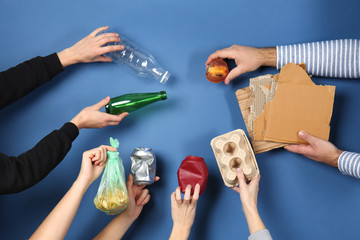 Many hands with different types of garbage on color background. Ecology concept