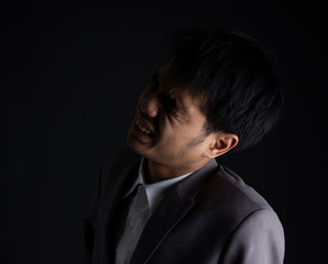 Obraz premium Emotion of depressed businessman having something in mind to worry on head. failure of business concept isolated on dark background.
