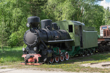 Fototapeta na wymiar Old train and locomotive. Railroad tracks stretches and green grass and trees. Railway road environment background.