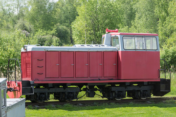 Naklejka premium Old train and locomotive. Railroad tracks stretches and green grass and trees. Railway road environment background.