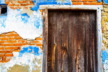 Old wooden door on decaying building