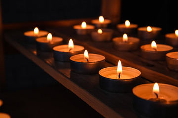 Burning candles on table in darkness