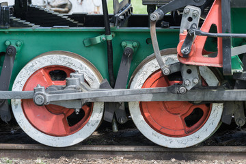 Old train and locomotive wheels. Railroad tracks stretches and green grass and trees. Railway road environment background.