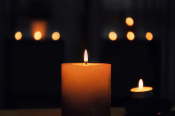 Fototapeta na wymiar Burning candle on dark background