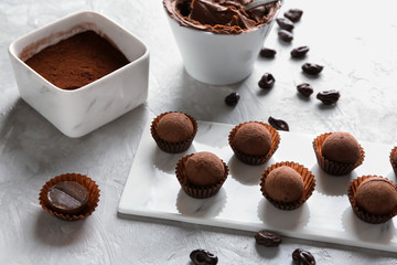 Tasty sweet truffles with cacao powder on grey table