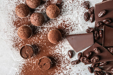 Tasty sweet truffles with cacao powder and chocolate on light table