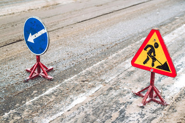 Snow-plow remove snow from the city street.Warning road sign.Winter service vehicle snow blower work.Cleaning snowy frozen roads.