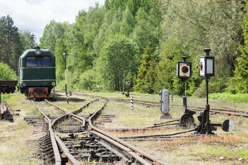 Old train and locomotive. Railroad tracks stretches and green grass and trees. Railway road environment background.