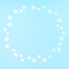 Christmas composition. Wreath made of snowflakes on pastel blue background. Christmas, winter, new year concept. Flat lay, top view, copy space