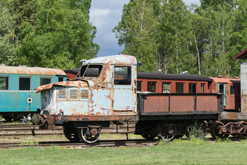 Fototapeta na wymiar Old train and locomotive. Railroad tracks stretches and green grass and trees. Railway road environment background.