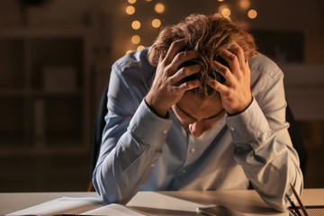 Young man suffering from headache late in evening