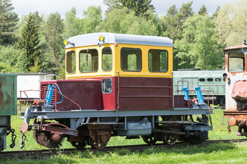 Old train and locomotive. Railroad tracks stretches and green grass and trees. Railway road environment background.