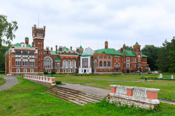 Fototapeta premium Sheremetev castle palace and park ensemble in the village of Yurino on the bank of the Volga, combination of different architectural styles in one building. Cloudy weather at the beginning of summer.
