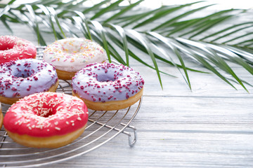 Cooling rack with tasty doughnuts on wooden table