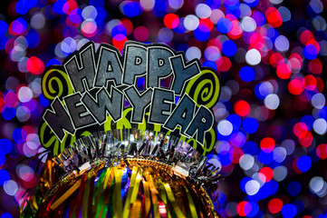 Obraz premium Happy New Year party hat sparkling against a glowing holiday celebration background in a colorful bokeh lights night view