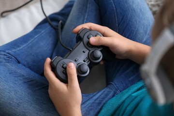 Cute boy playing video game at home
