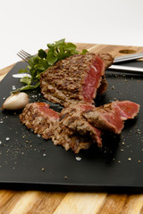Succulent and juicy rare beef steak, with watercress and garlic garnish