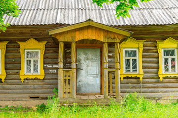 Wooden house withcarved platbands in the village of Yurino on the bank of the Volga. Russian traditional architecture lies in wooden houses with manually carved decorations, often painted in white.