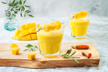 Mango Lassi, yogurt or smoothie with turmeric. Healthy probiotic Indian cold summer drink