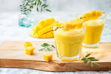 Mango Lassi, yogurt or smoothie with turmeric. Healthy probiotic Indian cold summer drink - obrazy, fototapety, plakaty